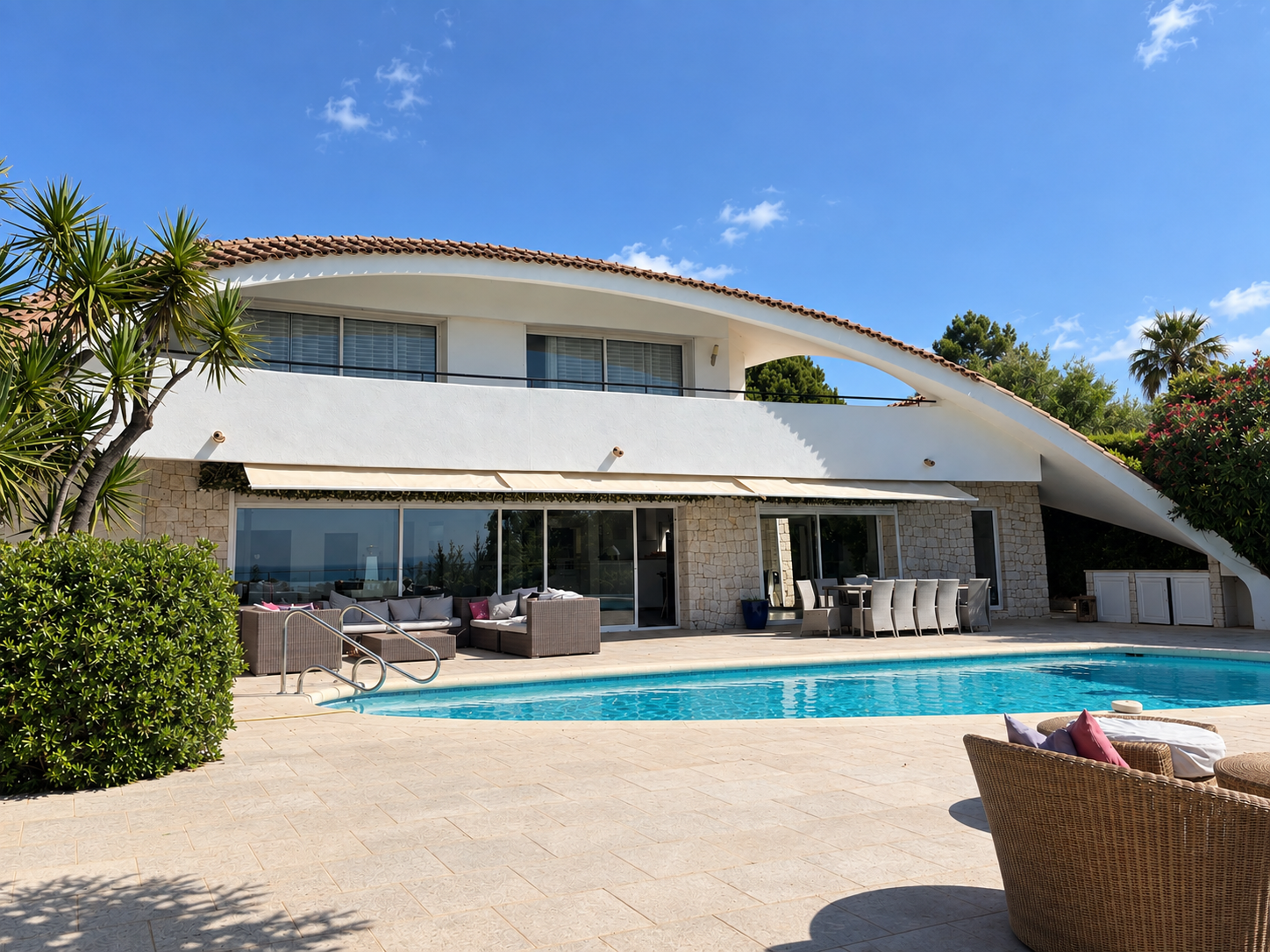 Villa Oxygène pool terrace and curved architecture under a blue sky